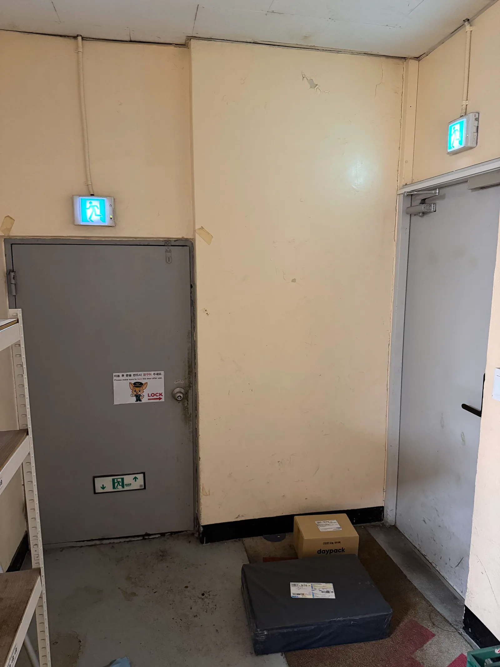 Small gray door on the left, beside the taller back door on the right